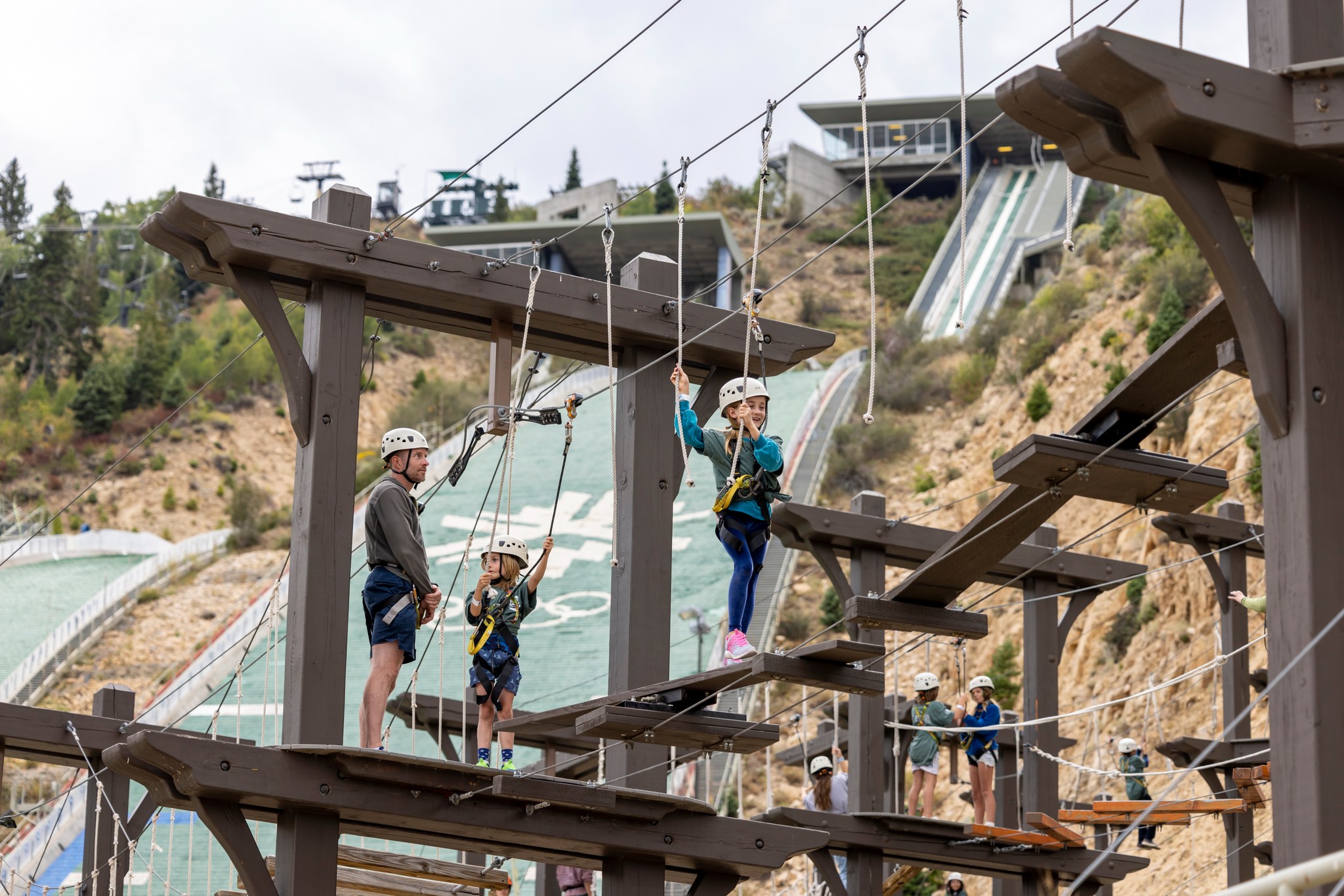 A man and children doing a rope course.